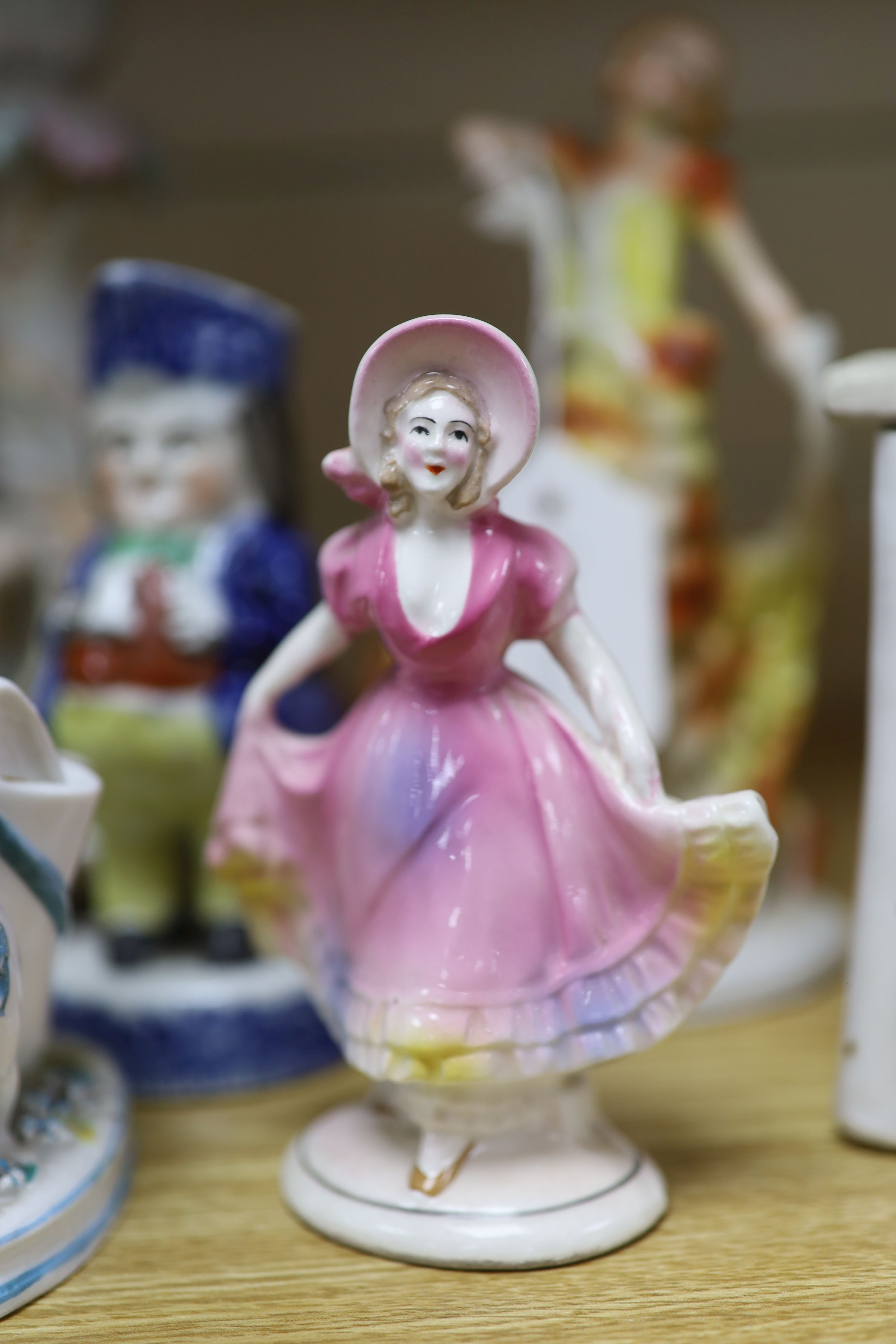 A collection of Art Deco ceramic dancing ladies, a 19th century figural box, a candlestick and a Toby jug, etc., tallest 22cm